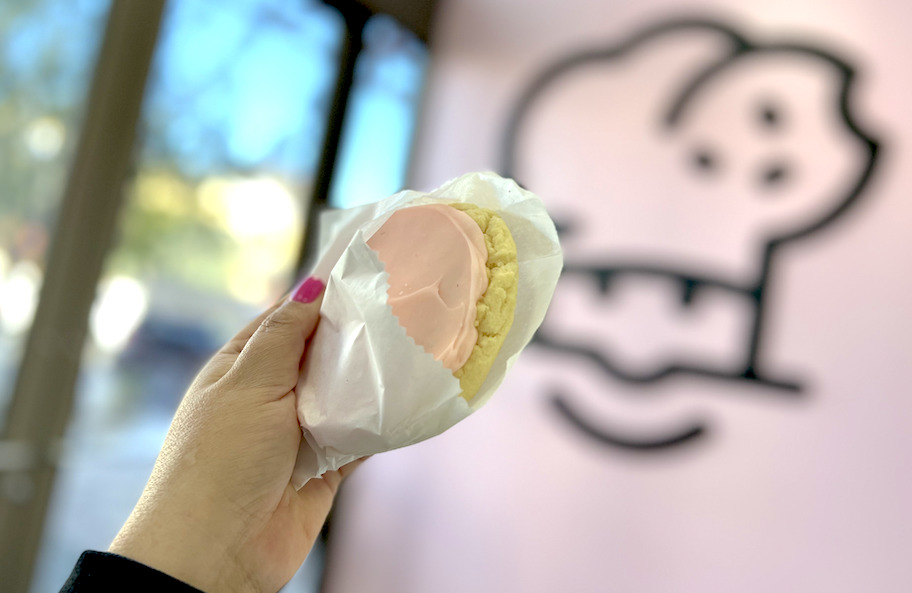 hand holding a crumbl sugar cookie with pink frosting