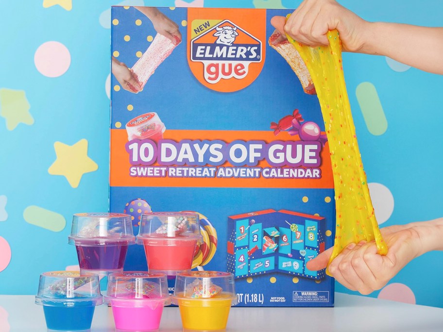 elmers glue advent calendar box on table with glue cups on table and person holding slime 