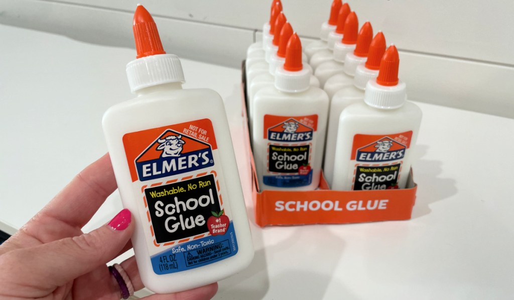 woman holding a bottle of elmer's glue