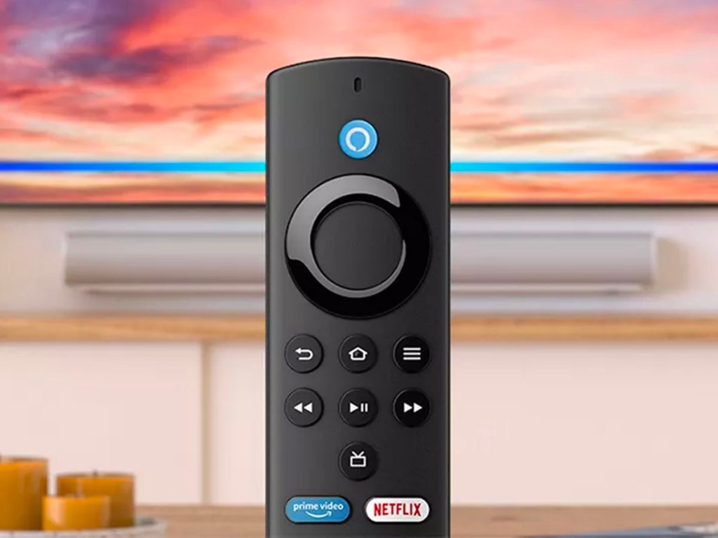 fire stick tv remote with tv behind it