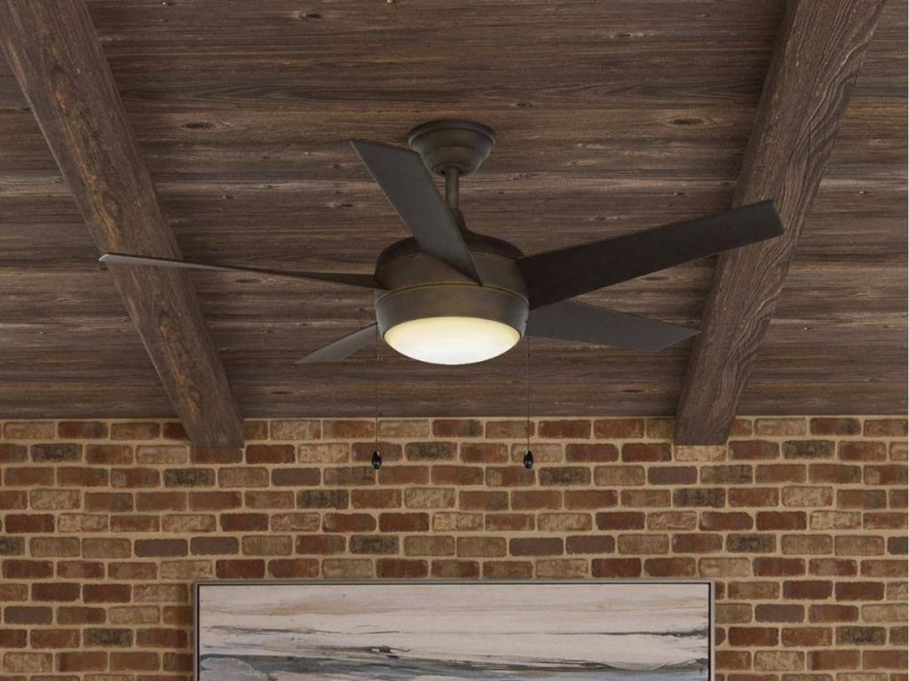 black fan with light hanging from wood ceiling