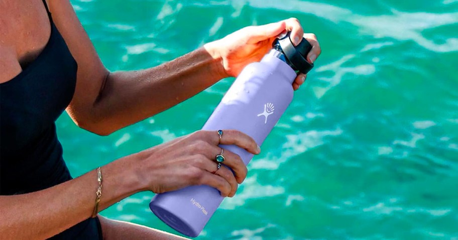 hand holding water bottle at pool