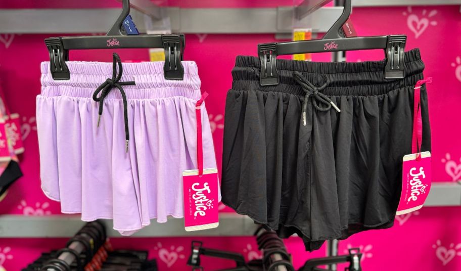 two pair of justice girls flutter shorts hanging on racks in a walmart store