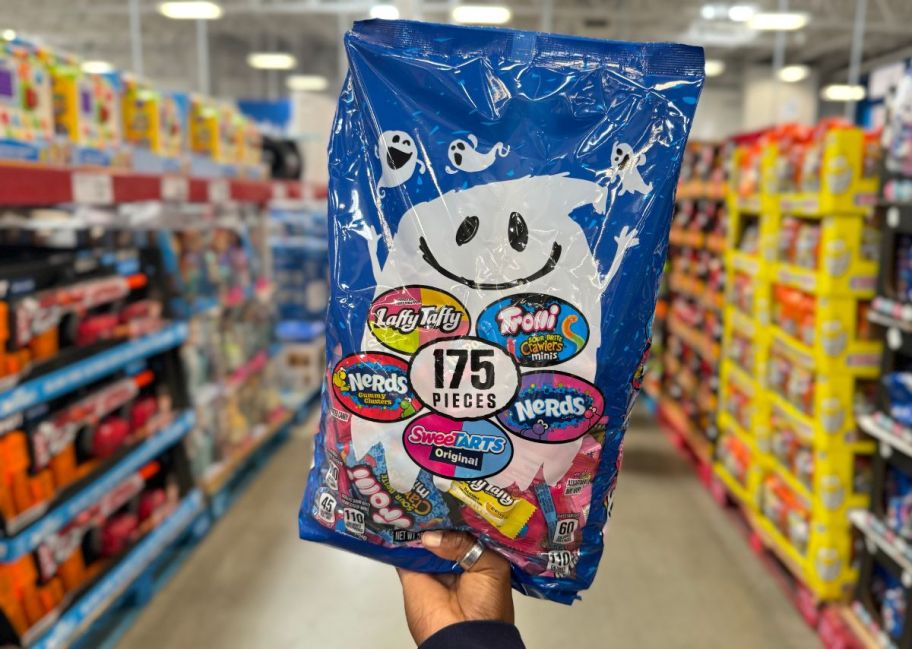 a womans hand holding a 175 count bag of halloween candies