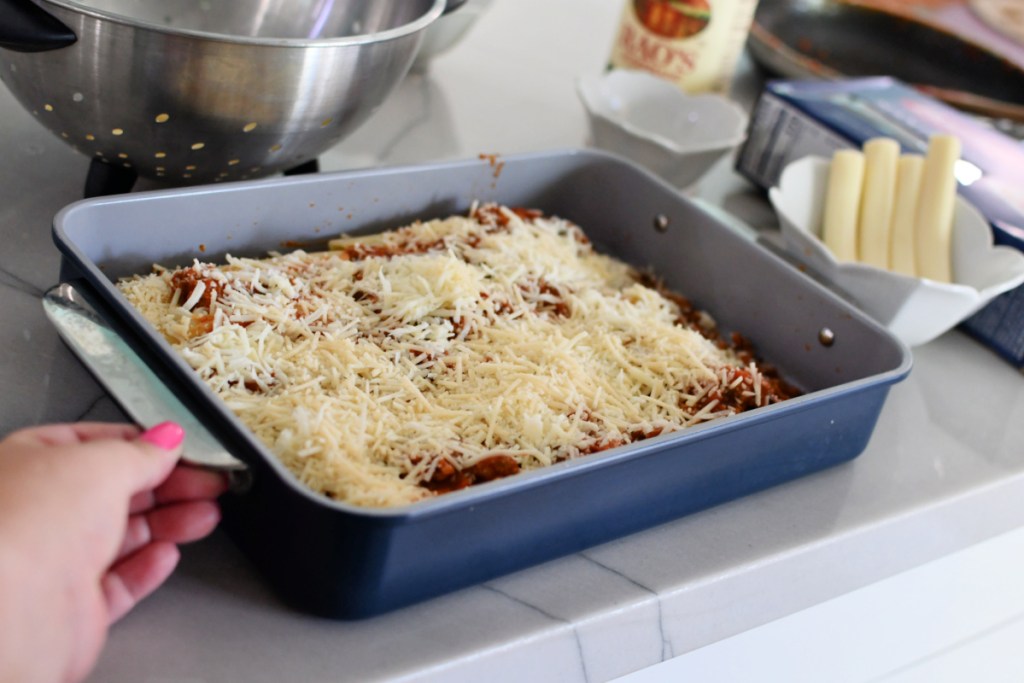manicotti casserole with shredded cheese on top before baking