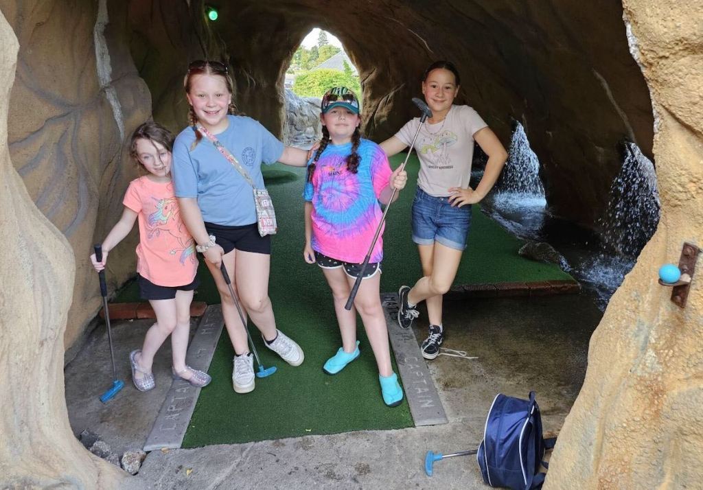 kiddos standing inside cave at mini golf course