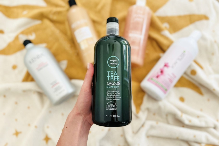 hand holding up a 1-liter bottle of Paul Mitchell Tea Tree Special Shampoo