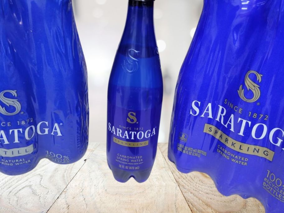 Saratoga Sparkling Water bottle sitting on counter next to packages of Saratoga Sparkling water