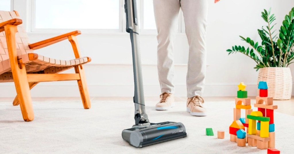 person vacuuming living room carpet