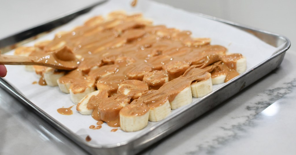 spreading peanut butter on sliced bananas