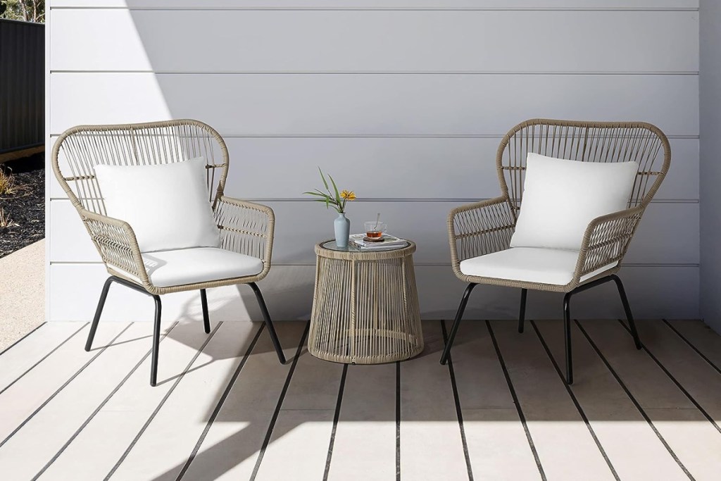 two rattan chairs and coffee table against white slatted wall