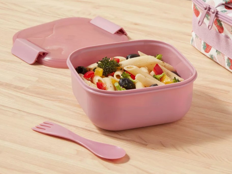 pink bento salad box on wooden tabletop