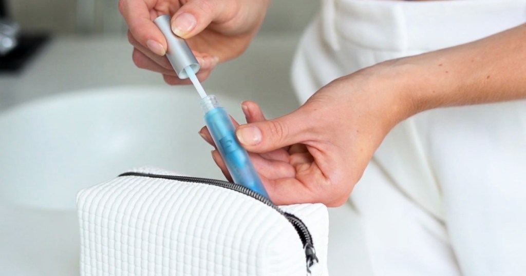 woman taking Blue Copper Lip Plumper out of cosmetics bag