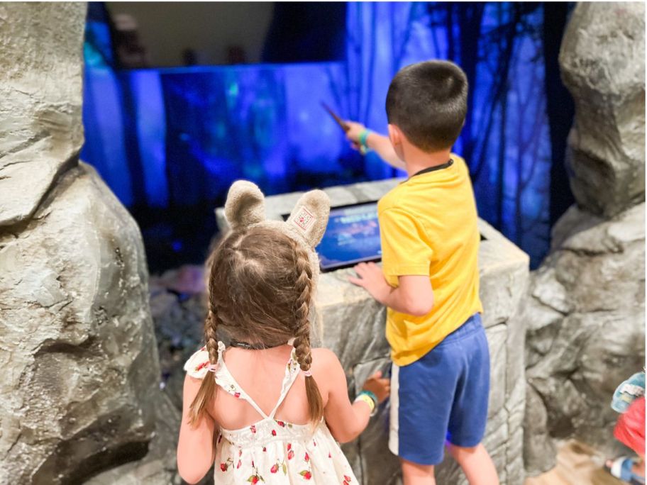 boy and girl using wand at amusement park