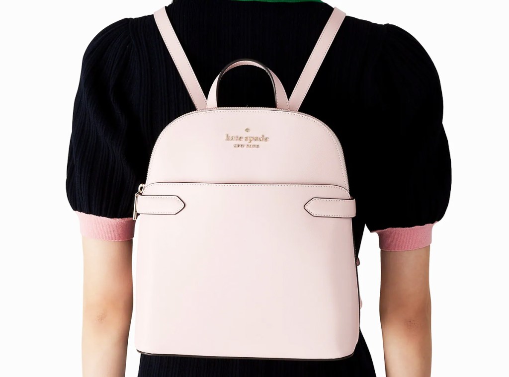 woman in a black top with a pink kate spade backpack