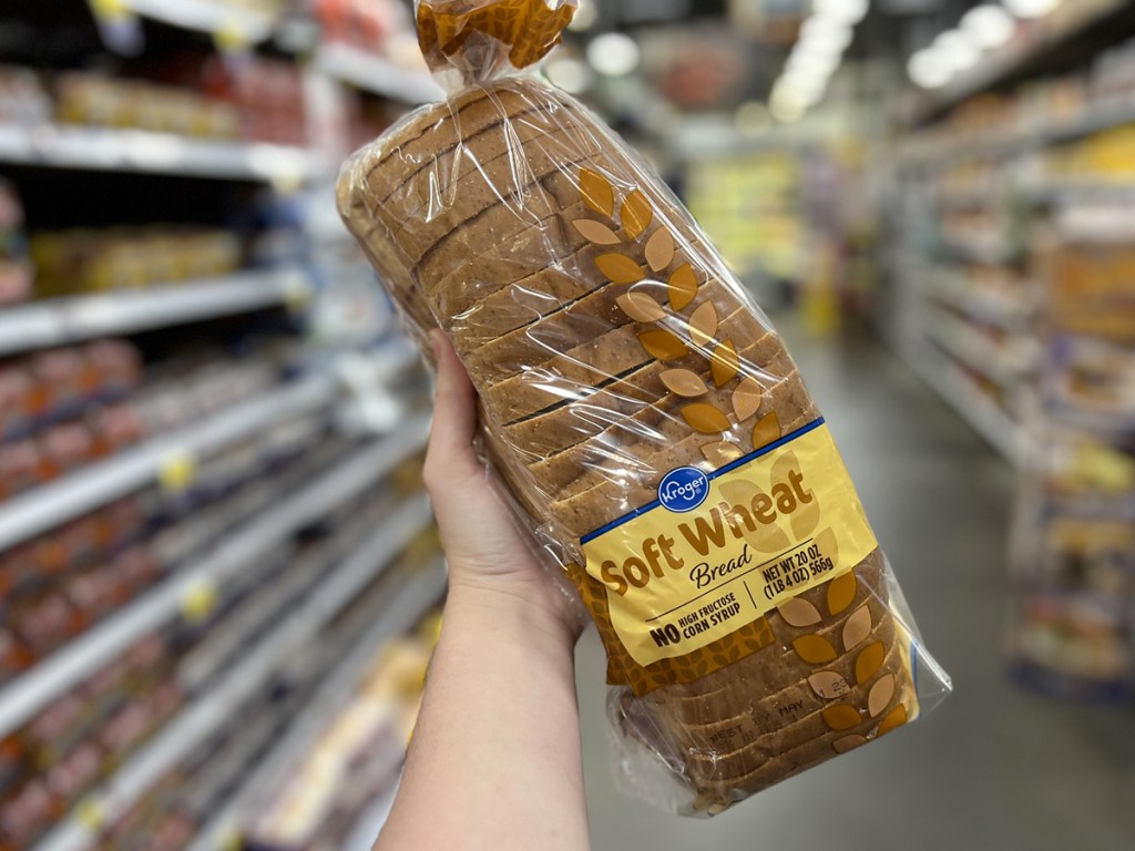 hand holding a loaf of kroger bread