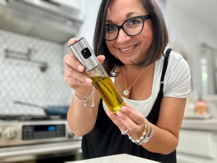 Woman holding up an oil sprayer
