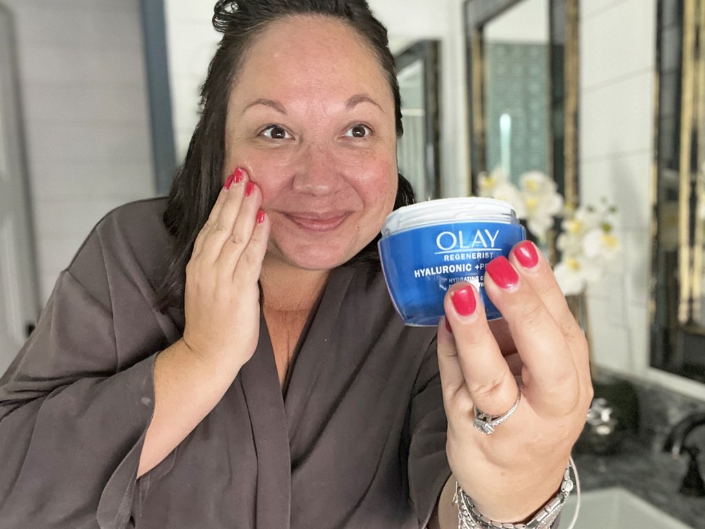 woman holding up a blue jar of olay hyaluronic mositurizer