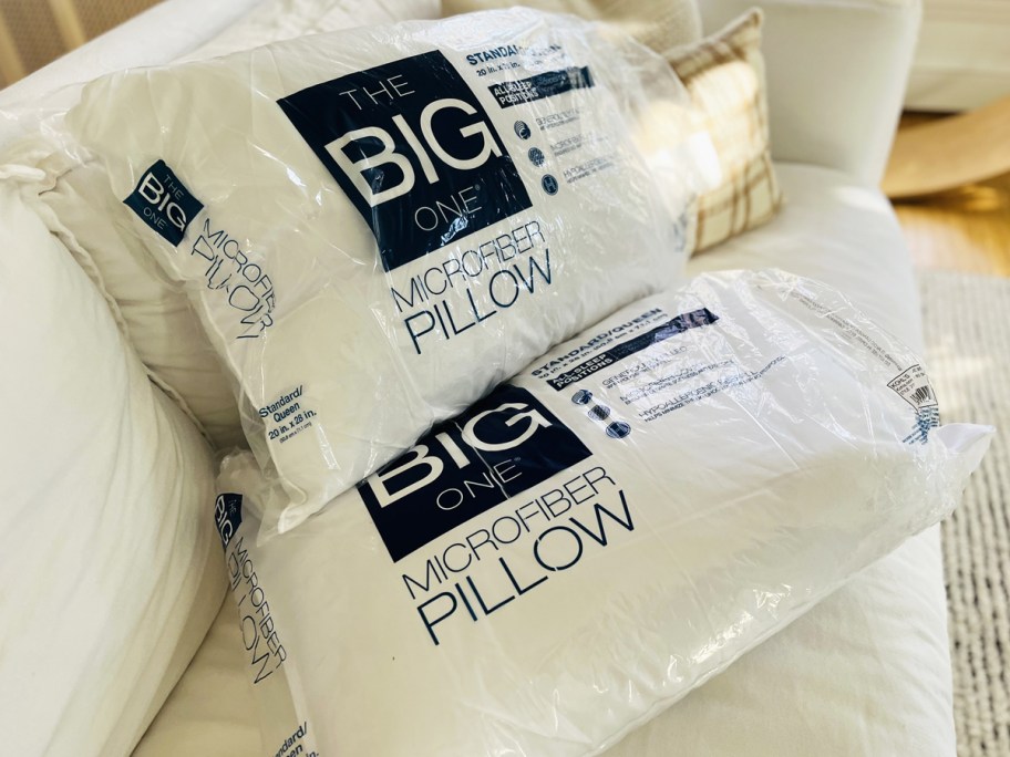 two big one bed pillows on white couch