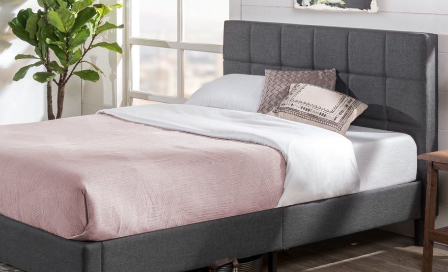 a gray queen sized platform bed with tufted headboard
