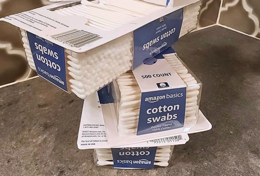 3 packs of cotton swabs stacked on a kitchen counter