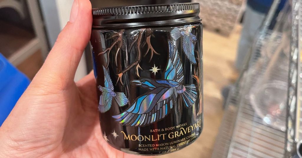 Hand holding a Bath & Body Works Moonlit Graveyard single wick candle