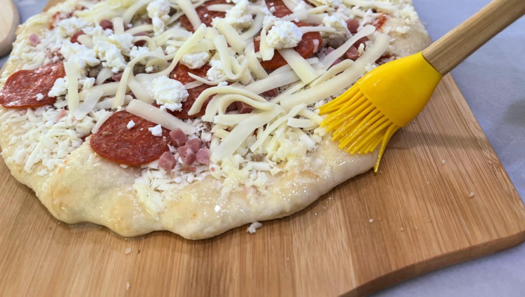 butter and season the crust of a pizza before baking