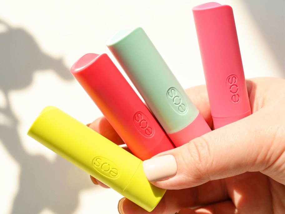 hand holding 4 eos lip balms