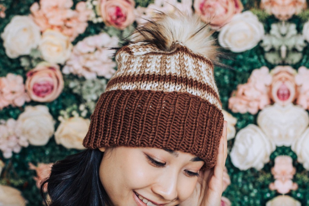 woman in brown pom crochet hat