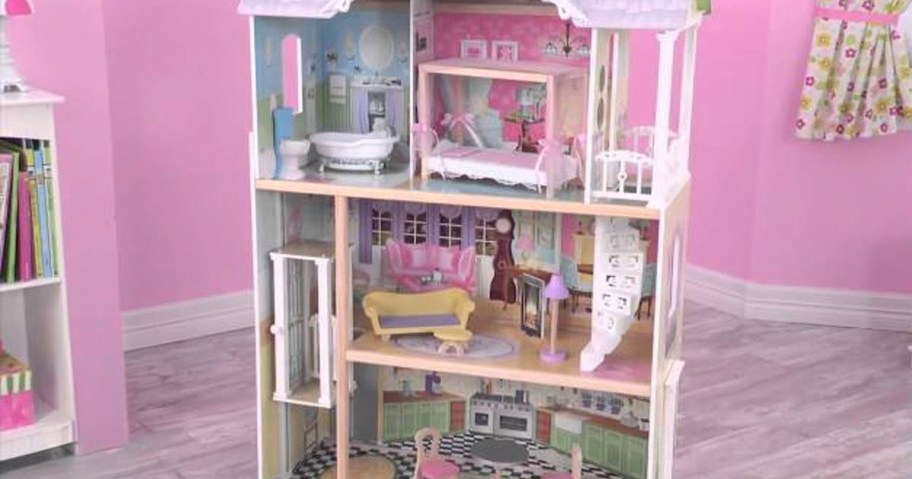 wooden dollhouse in pink bedroom 