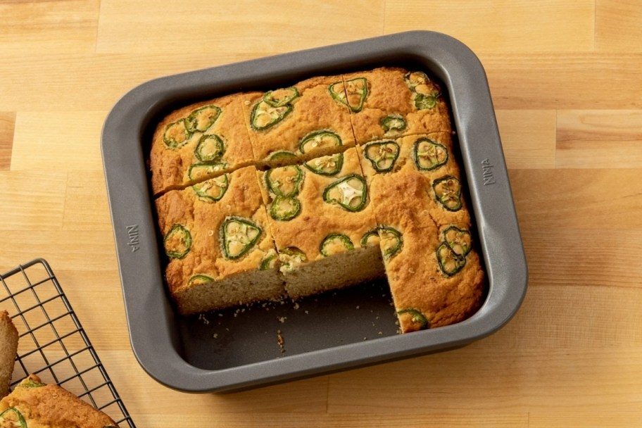 an 8 inch square cake pan with jalapeno cornbread baked in it