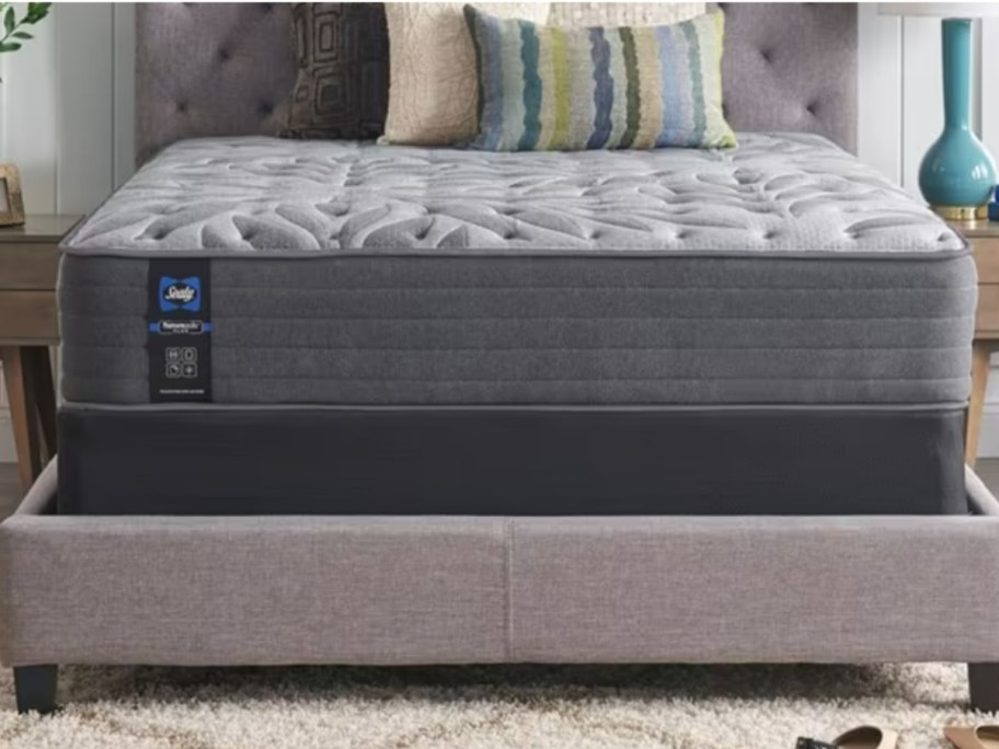 a mattress on a grey platform bed frame in a bedroom