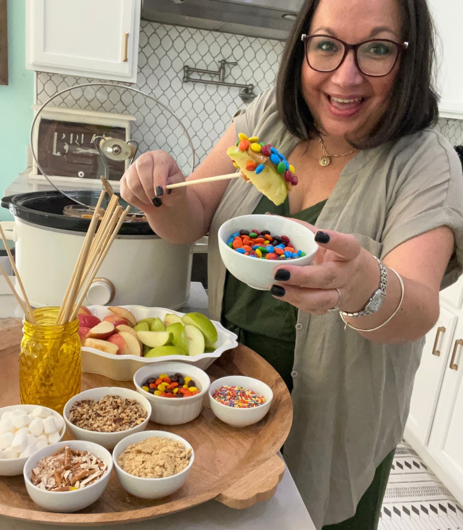 woman serving a Caramel apple charcuterie board