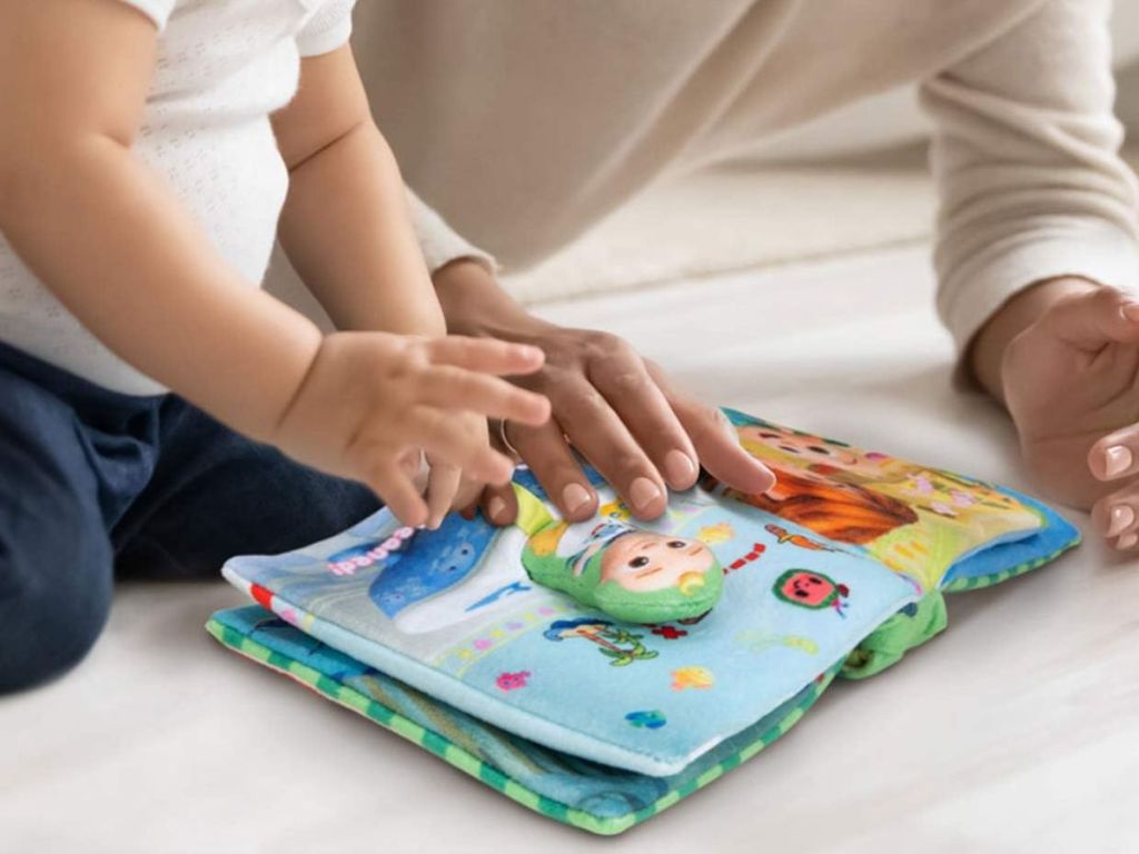 A baby reading Cocomelon Nursery Rhyme Book