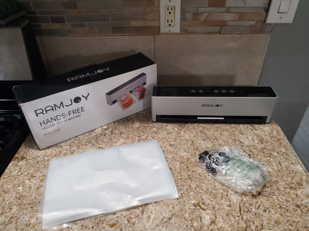 RAMJOY Hands Free Vacuum Food Sealer shown with box, bags and accessories