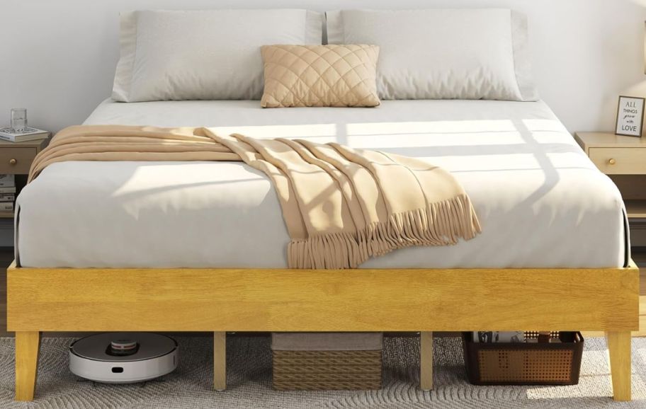 a wooden platform bed with pillows 