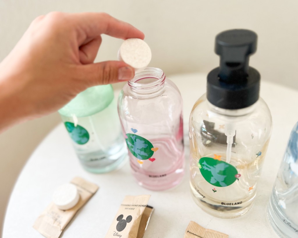 hand dropping soap tablet into bottle