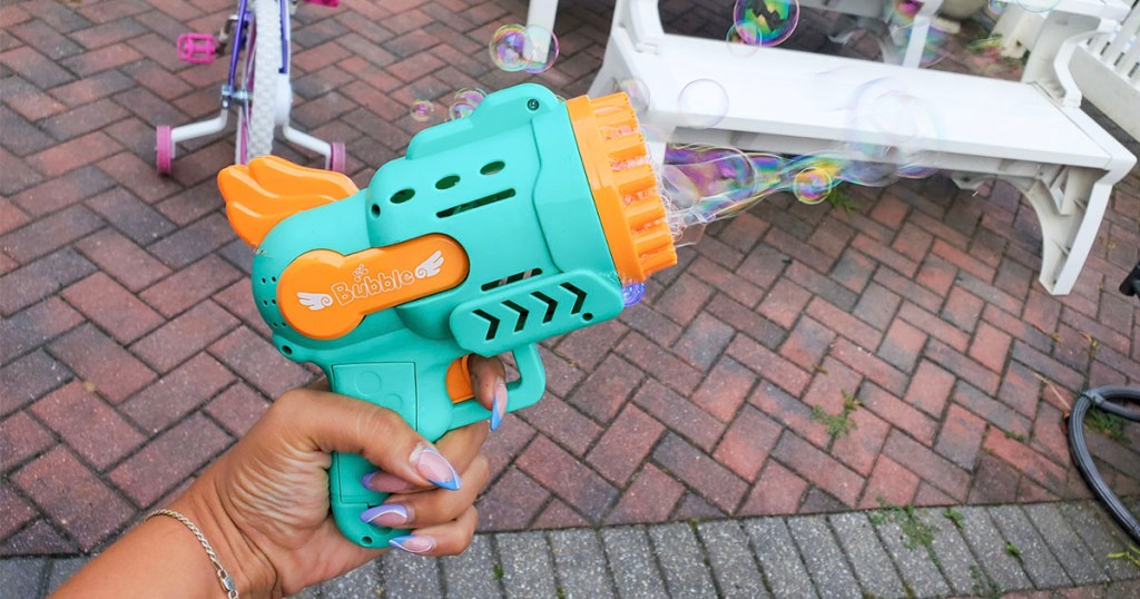 hand using teal and orange bubble blower