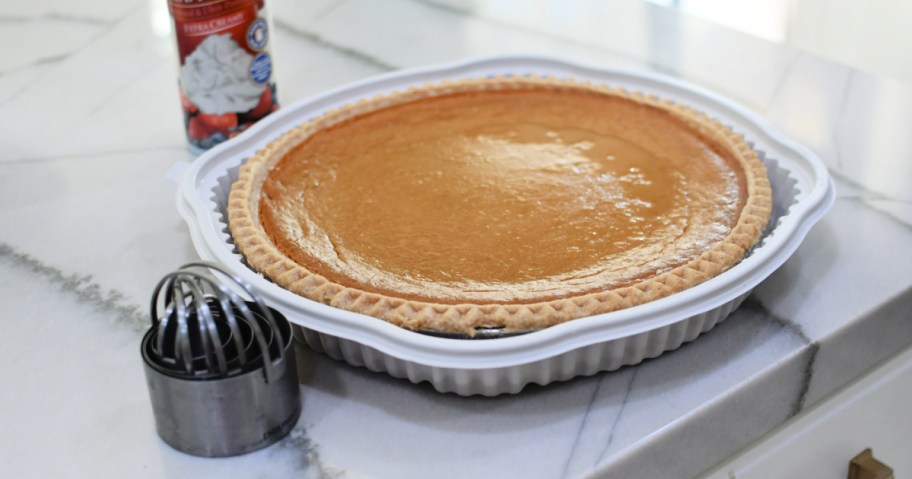 Costco pumpkin pie on the counter with biscuit cutters