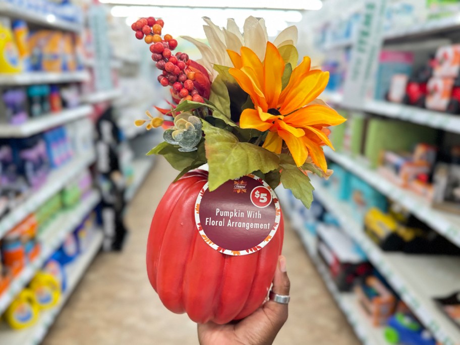 hand holding pumpkin floral arrangment