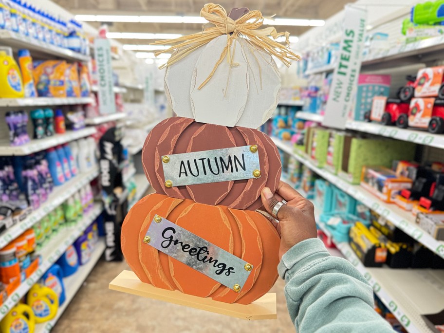 hand holding pumpkin wooden decor