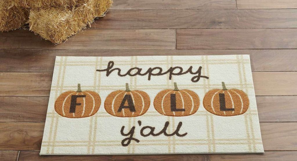 happy fall y'all rug on the floor next to hay