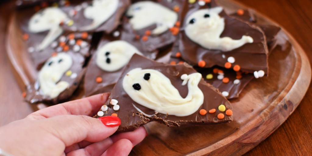 holding a piece of halloween bark