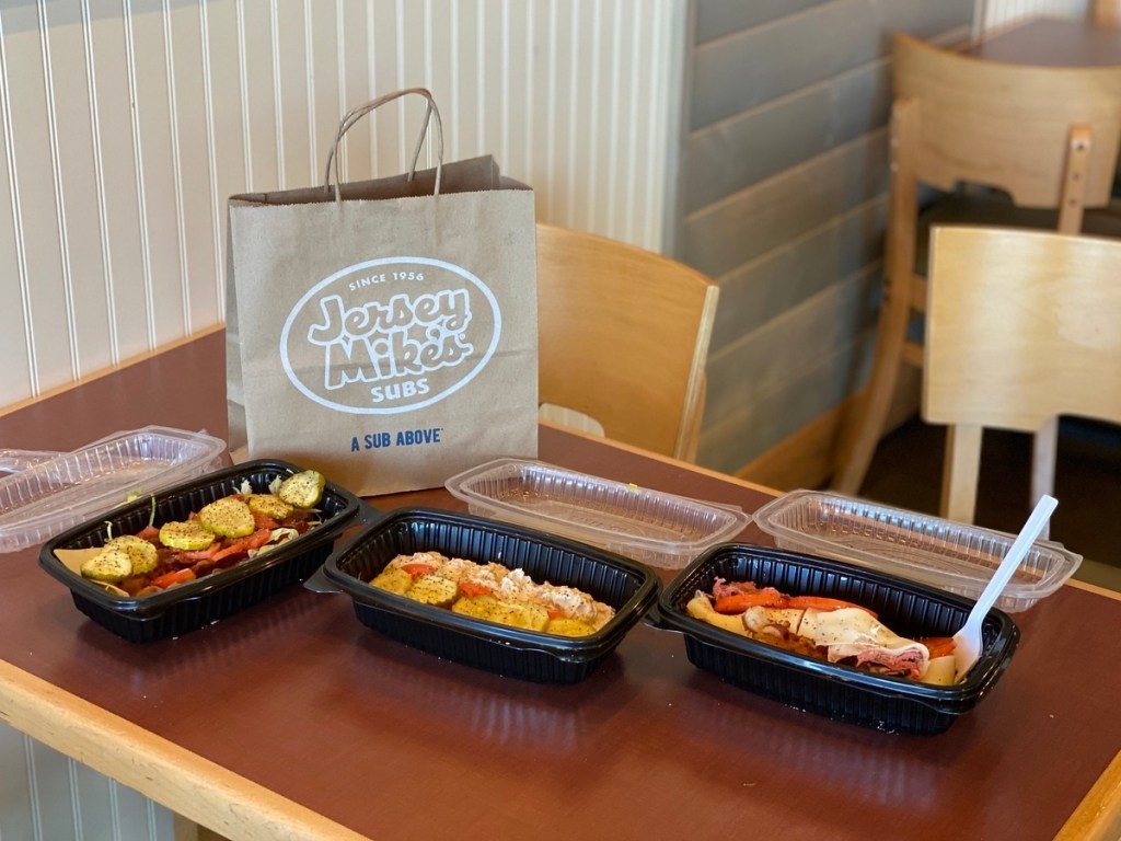 Jersey Mike's bag on table next to subs in tubs