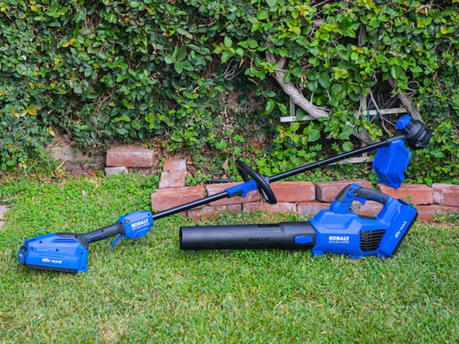 blue and black kobalt trimmer and blower sitting on grass 