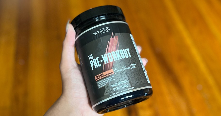 hand holding pre workout container 