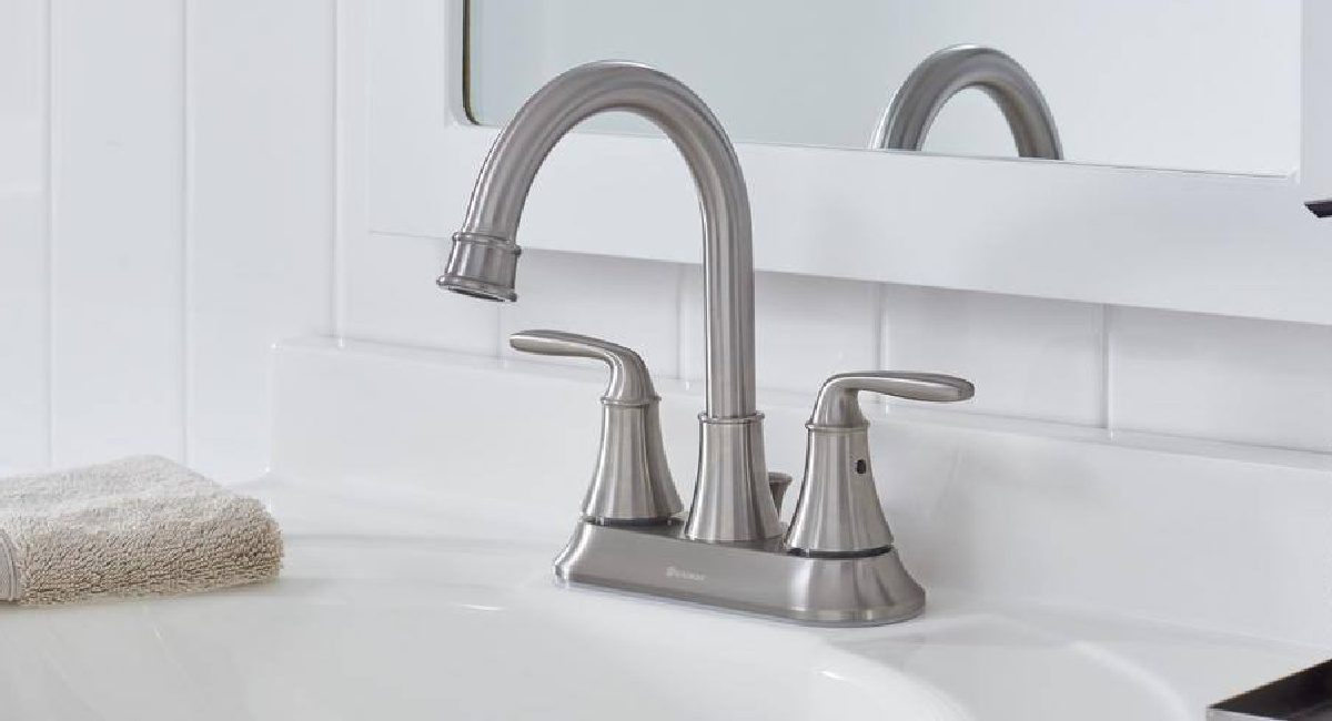 nickel brushed bathroom faucet displayed with mirror in the background and tool