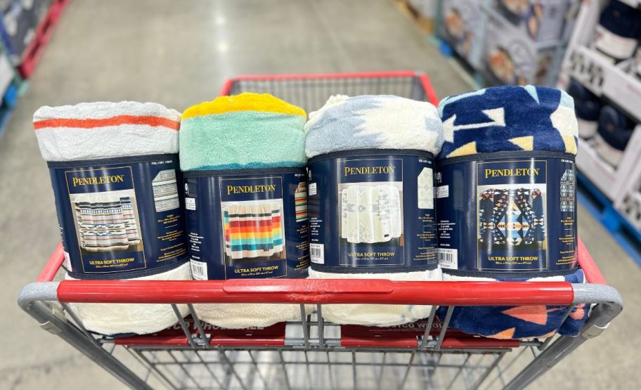 four rolled throw blankets in a shopping cart in a costco club