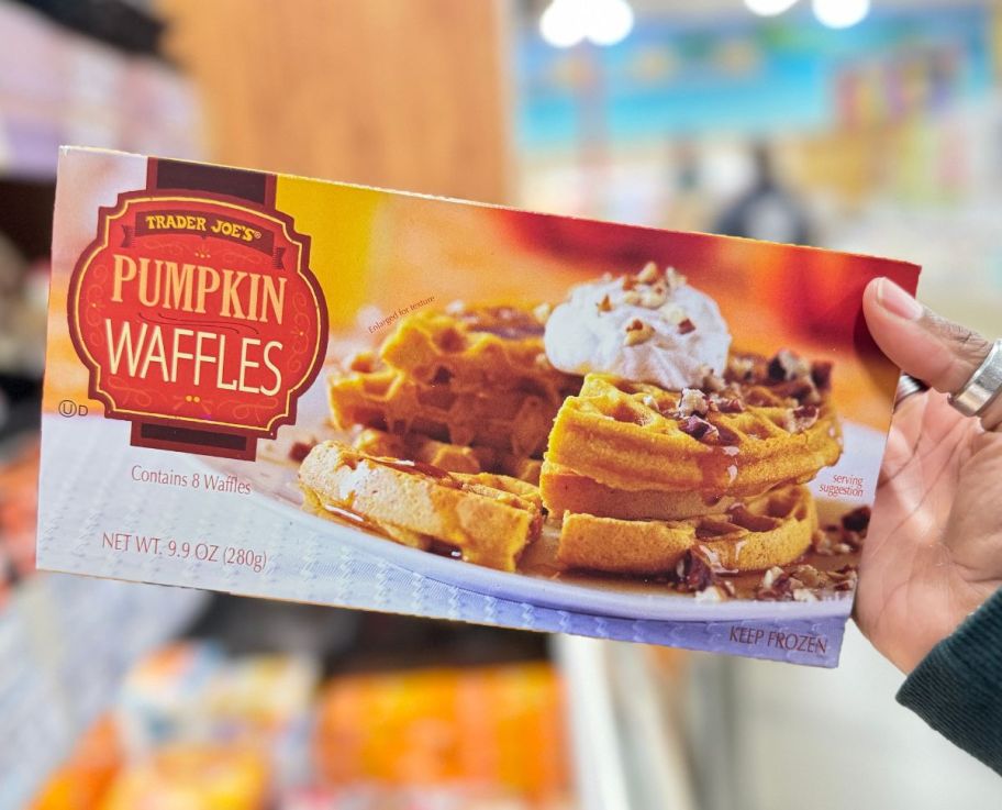 a womans hand holding a box of pumpkin spiced waffles