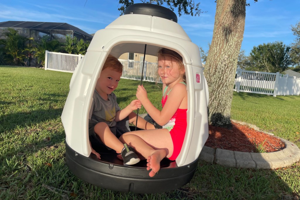 two kids in rocket ship swing